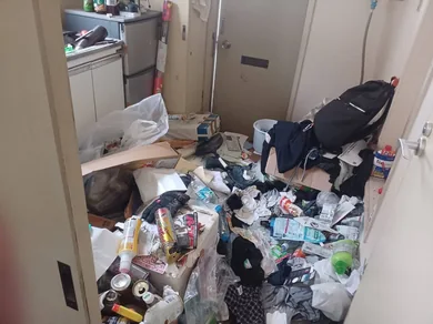 袋や包装材などが床に積み重なった室内