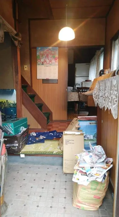 整理前：箱や生活用品が残る玄関